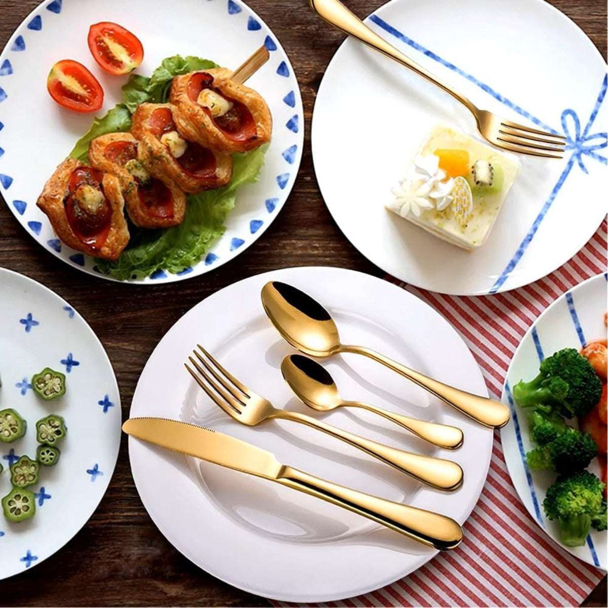 Eleven Formula gold stainless steel flatware set styled on a dining table with plated meals, highlighting its elegant table presence.