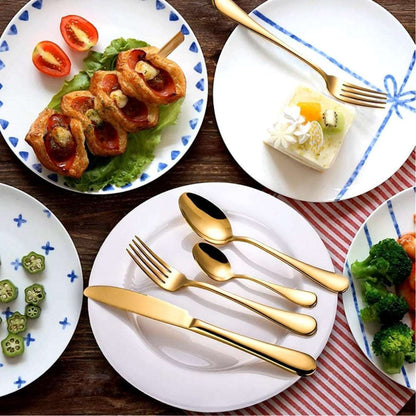 Eleven Formula gold stainless steel flatware set styled on a dining table with plated meals, highlighting its elegant table presence.