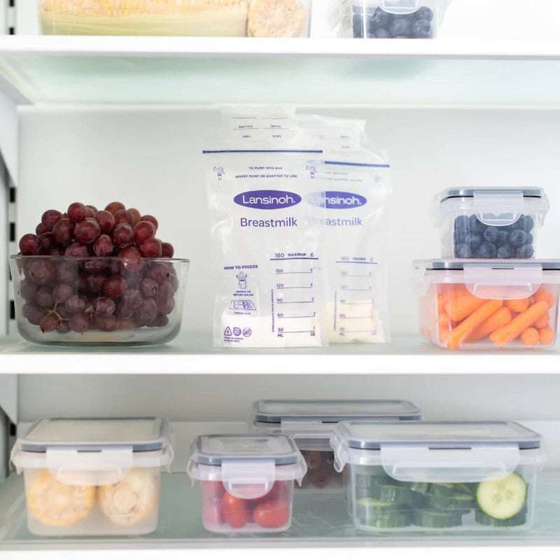 Lansinoh Breastmilk Storage Bags stored upright in a refrigerator among fresh produce, showcasing leakproof and freezer-safe milk storage solution.