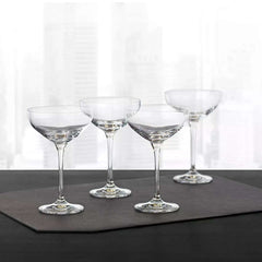 Set of four Hotel Collection Champagne Coupe Glasses 9.7 oz displayed on a dark mat, perfect for upscale home bar or entertaining settings.