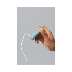 Bloomi Play Waterproof Rechargeable Mini Vibrator being charged via USB cable, emphasizing its rechargeable feature and modern wellness design.