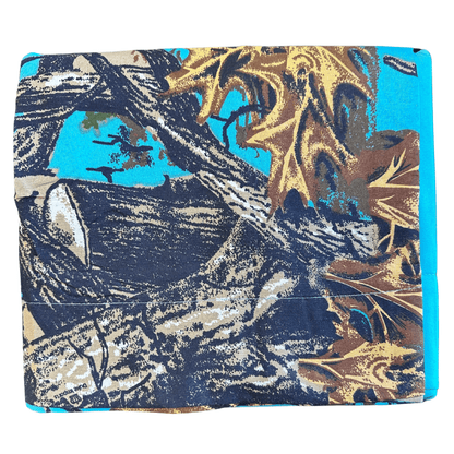 Folded The Woods Seabreeze Twin Sheet Set featuring a vibrant nature print with tree branches and autumn leaves on turquoise background.