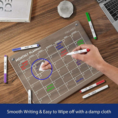 Volcanics Acrylic Magnetic Monthly Planner Dry Erase Board in use on desk, demonstrating smooth writing and easy wipe-off with damp cloth.