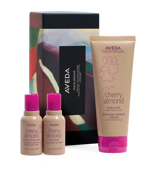 Aveda Cherry Almond Body Care Trio Gift Set with body scrub, lotion, and wash in floral packaging. Ideal bath & body gift set for soft, scented skin.