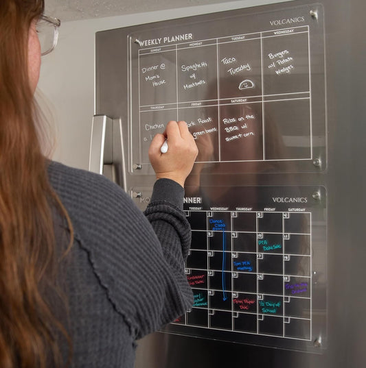 Volcanics Acrylic Magnetic Weekly Planner Dry Erase Board on fridge with handwritten weekly schedule, ideal for home or office organization.