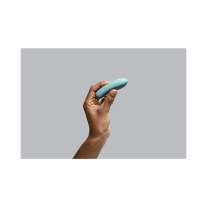 Bloomi Play Waterproof Rechargeable Mini Vibrator held between fingers, showcasing its discreet, compact design for targeted intimate stimulation.