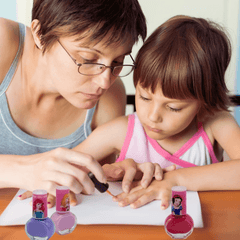 Adult helping child apply Disney Princess washable nail polish. Fun, safe nail care activity using non-toxic kids' polish set.