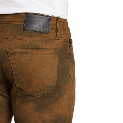 Brown jeans with a visible brand label 'AG'  on a white background