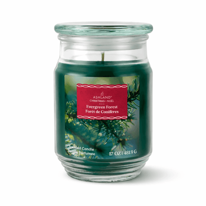 Green candle in a glass jar with a red label on a white background. Evergreen Forest scented.