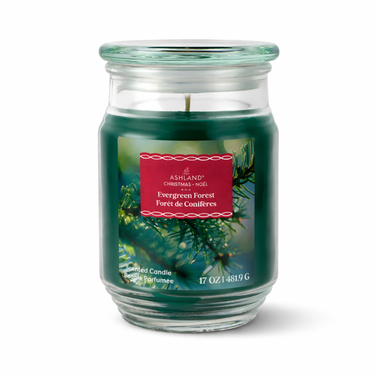 Green candle in a glass jar with a red label on a white background. Evergreen Forest scented.