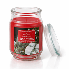 Unlit holiday scented candle in glass jar with festive label for home ambiance