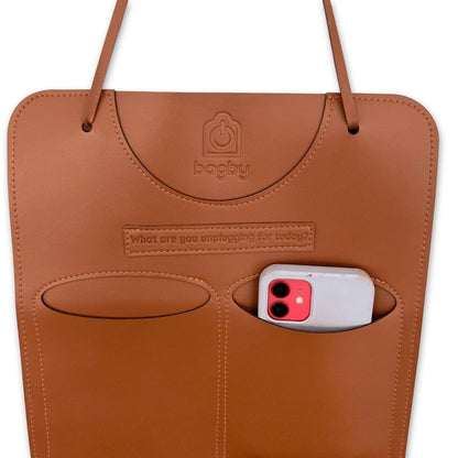Brown leather bag with a phone pocket on a white background