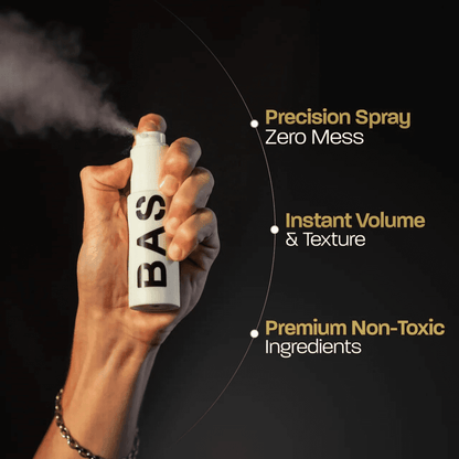 Hand holding spray bottle with styled hair