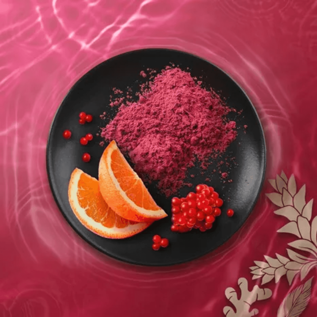 Close-up of pink and red powder with orange slices and berries on a black plate