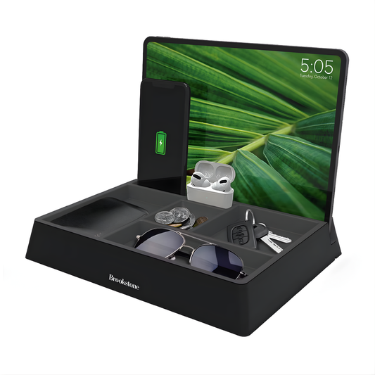 Black multi-device charging station with smartphone, AirPods, keys, and sunglasses on a white background.