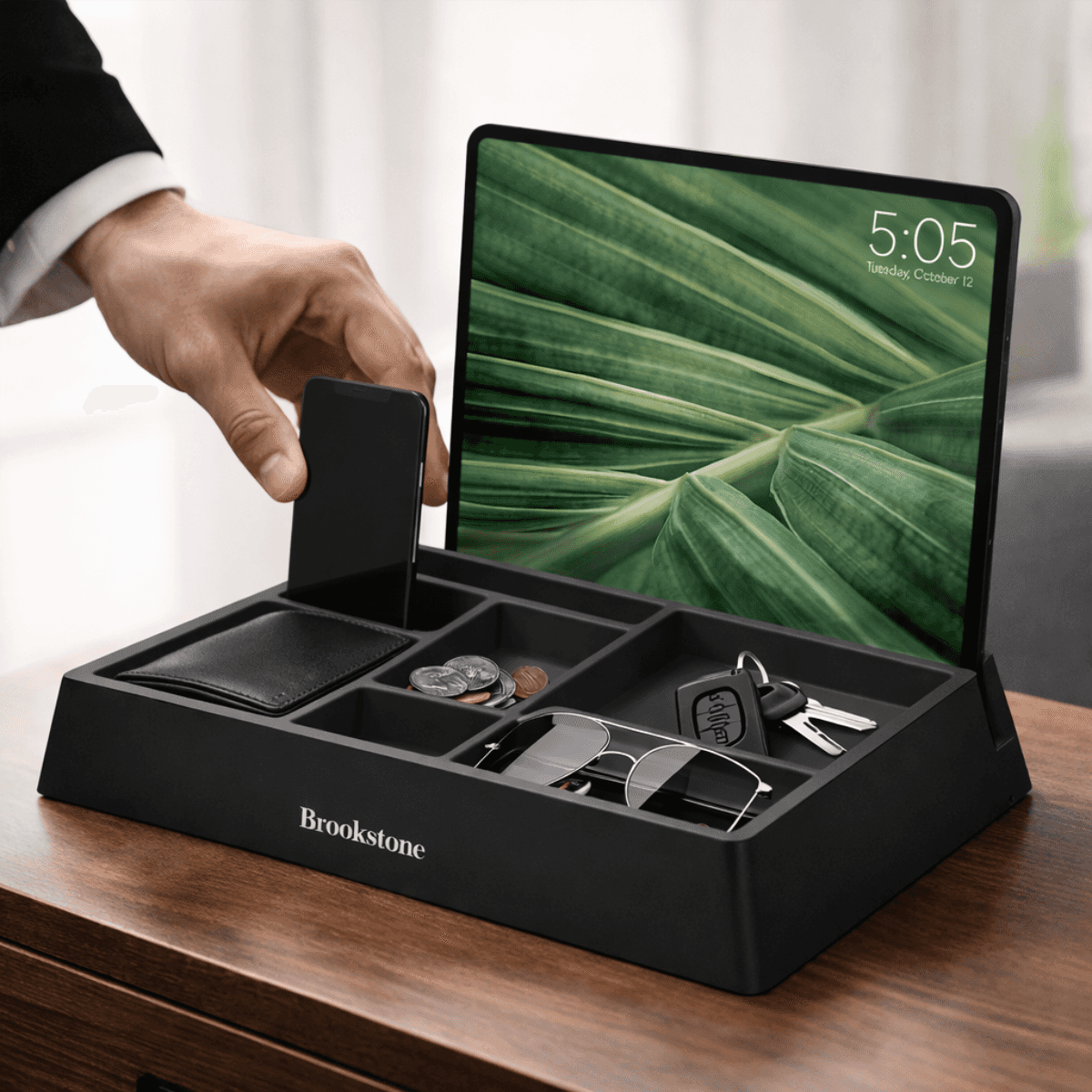 Black Brookstone organizer with electronic tablet displaying a leaf pattern on a wooden surface.