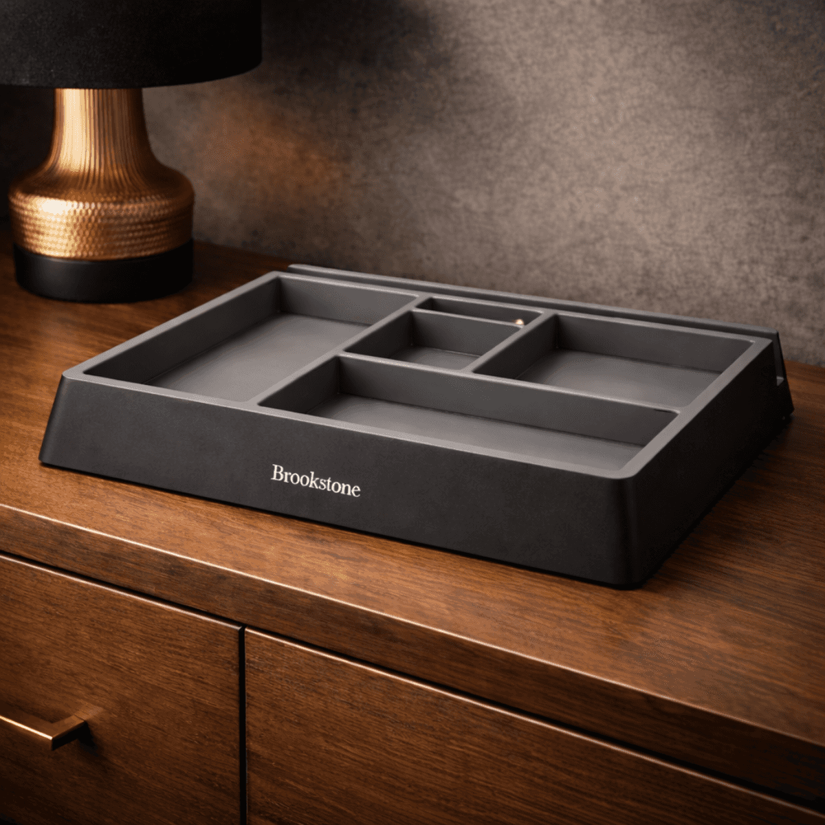 Gray Brookstone tray on a wooden surface with a gold lamp in the background