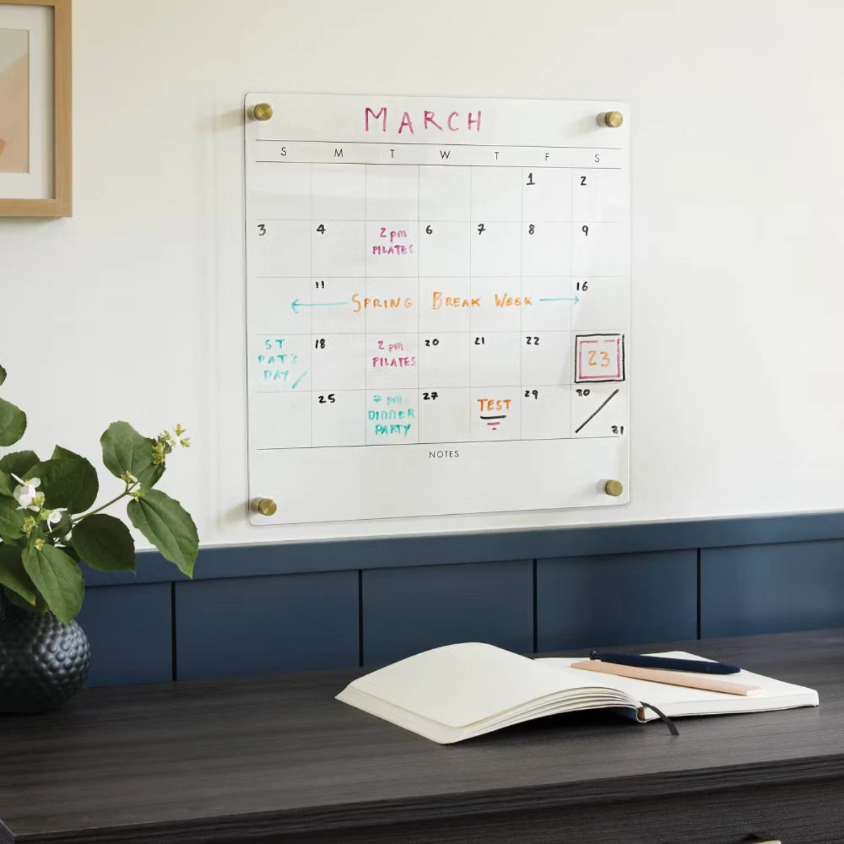 Wall-mounted dry erase calendar with colorful handwritten notes for planning and scheduling