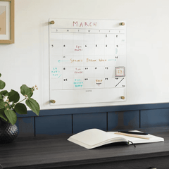 Wall-mounted dry erase calendar with colorful handwritten notes for scheduling and planning