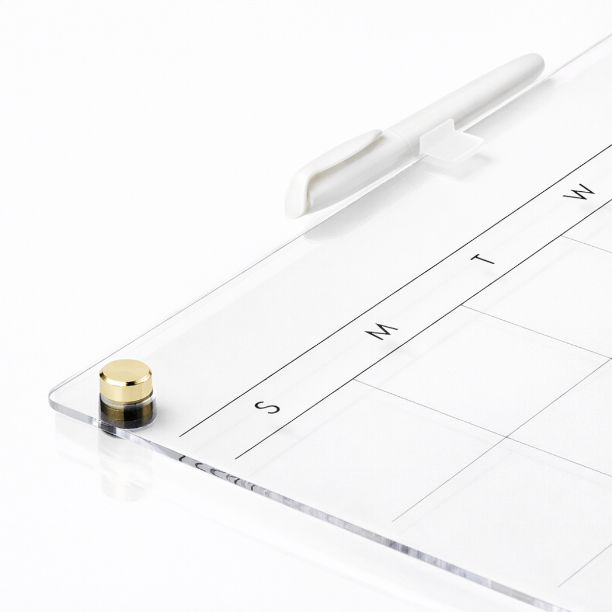 Close-up of dry erase marker and transparent acrylic surface with magnetic clips for organization