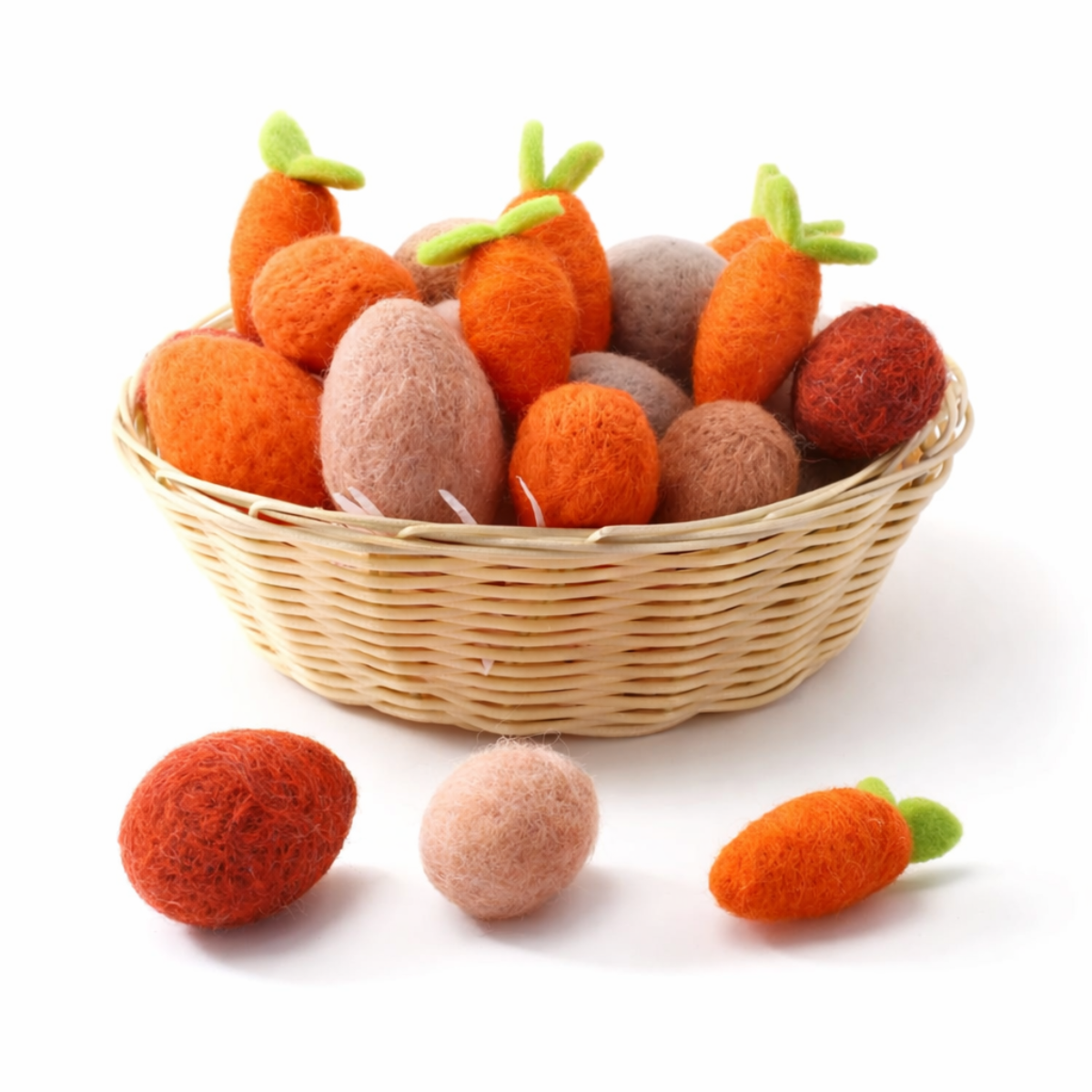 Wicker basket filled with felted carrot toys on a white background