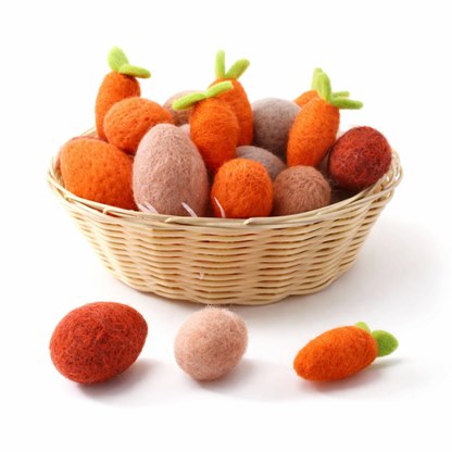 Wicker basket filled with felted carrot toys on a white background