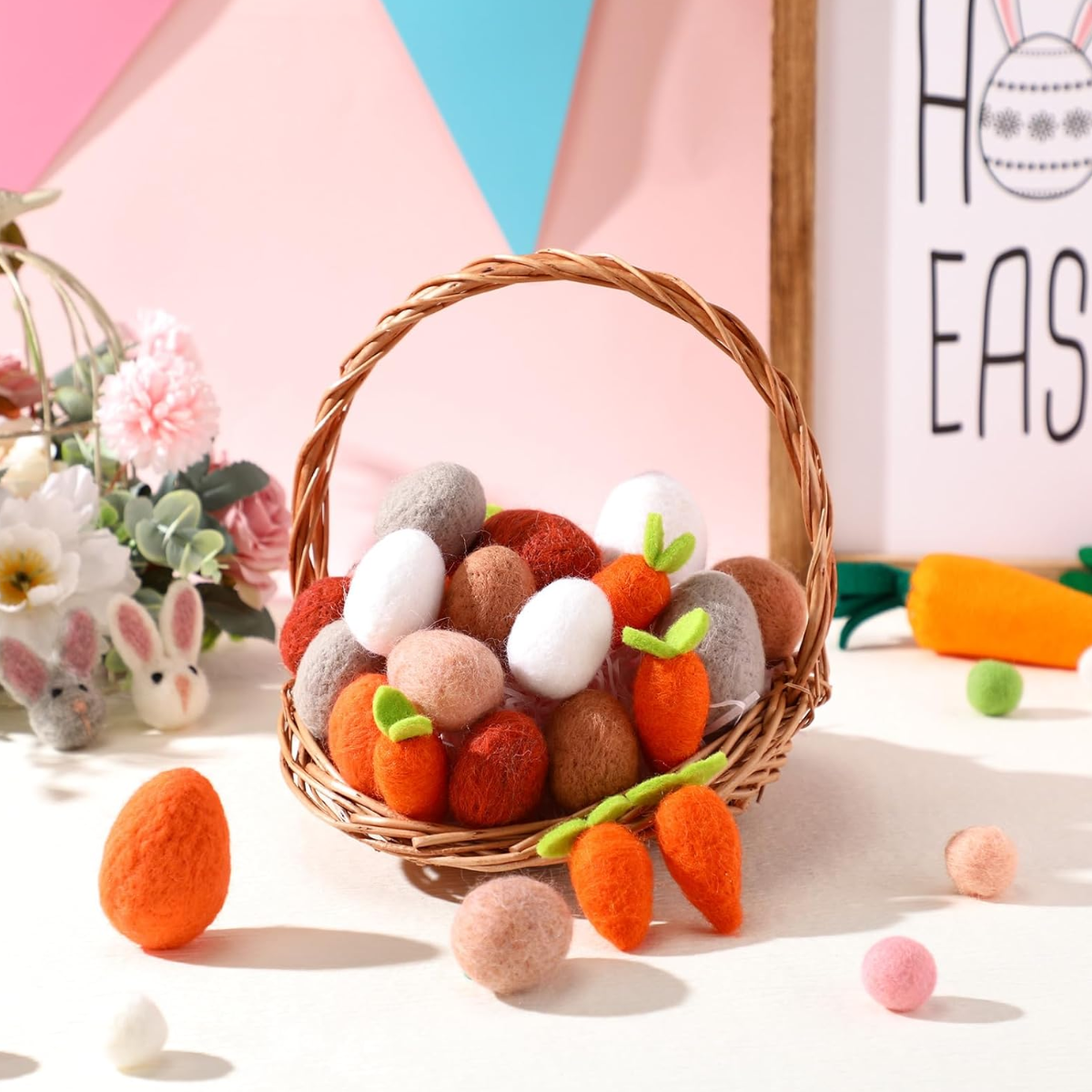 Wicker basket with felt Easter eggs and carrots on a colorful background