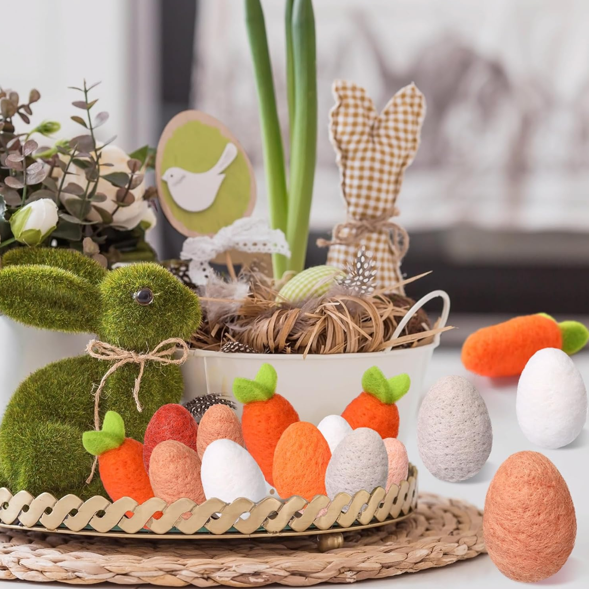 Decorative Easter display with a bunny, felt eggs, and carrots on a woven tray.