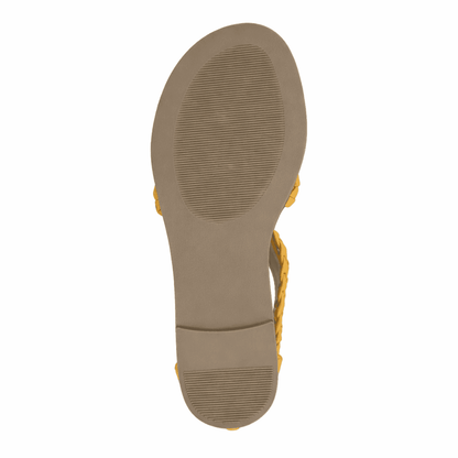 Close-up of a sandal sole by Journee Collection with Mustard color straps on a white background
