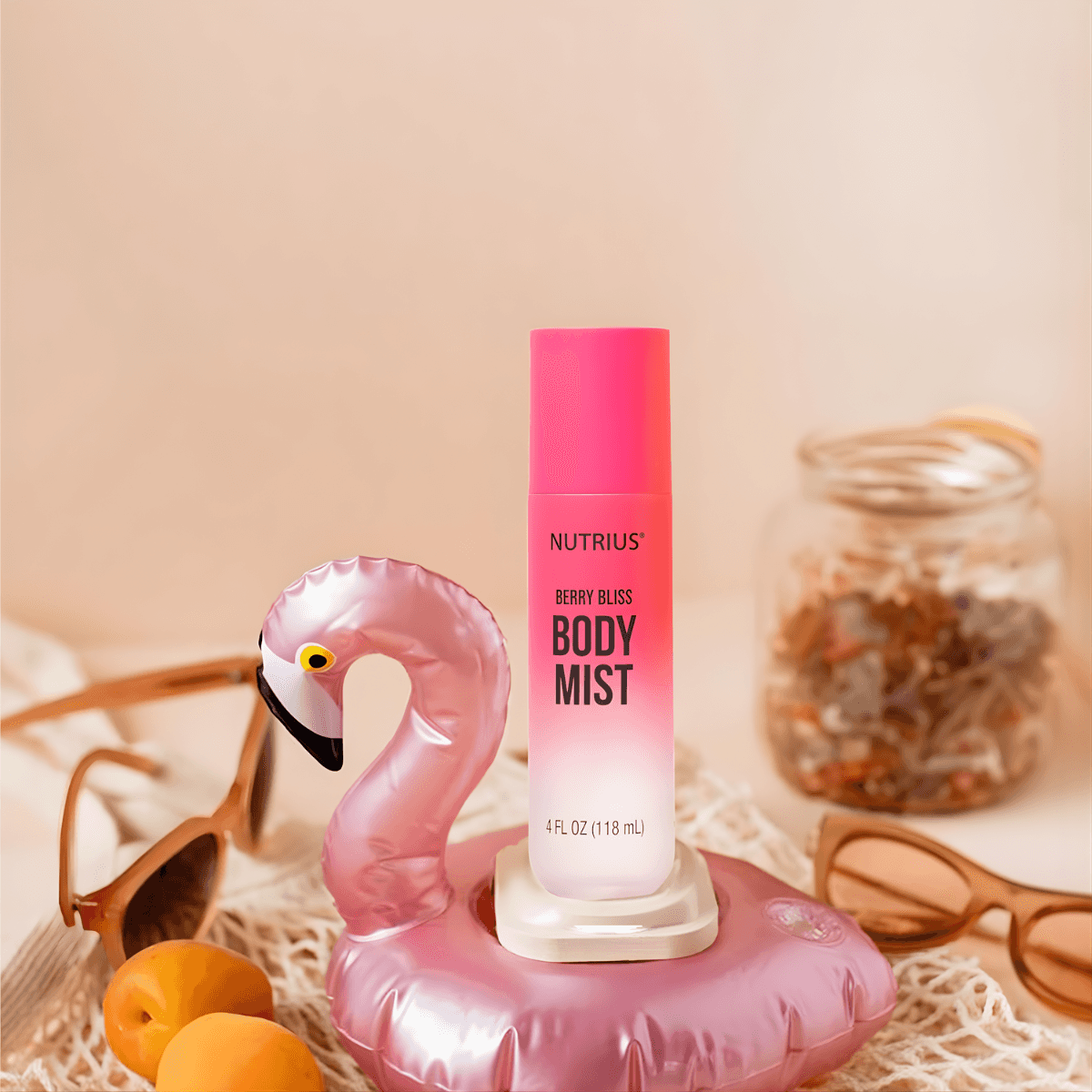 Nutrius Berry Bliss Body Mist Spray 4 oz in pink bottle with flamingo float, sunglasses, and jar of dried flowers