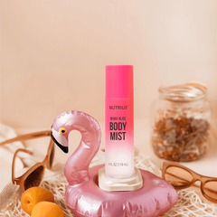 Nutrius Berry Bliss Body Mist Spray 4 oz in pink bottle with flamingo float, sunglasses, and jar of dried flowers