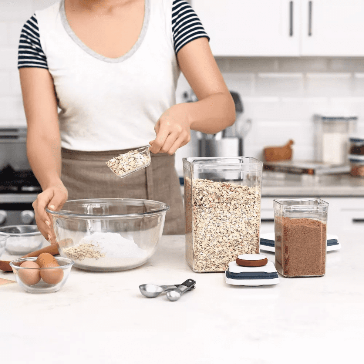 Kitchen storage containers with oats, flour, and brown sugar for baking