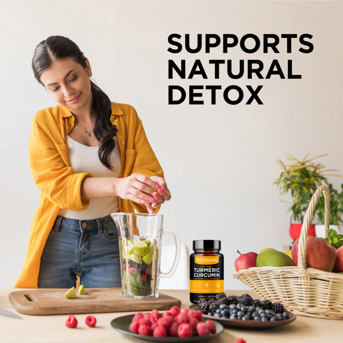 Woman preparing a smoothie with fruits and PhiNaturals Turmeric Curcumin with BioPerine® bottle, emphasizing natural detox support.