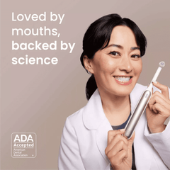 Woman holding electric toothbrush with replacement head, smiling