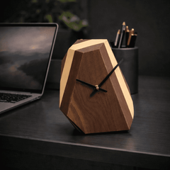 Wooden geometric clock on a desk with a laptop and pen holder in the background