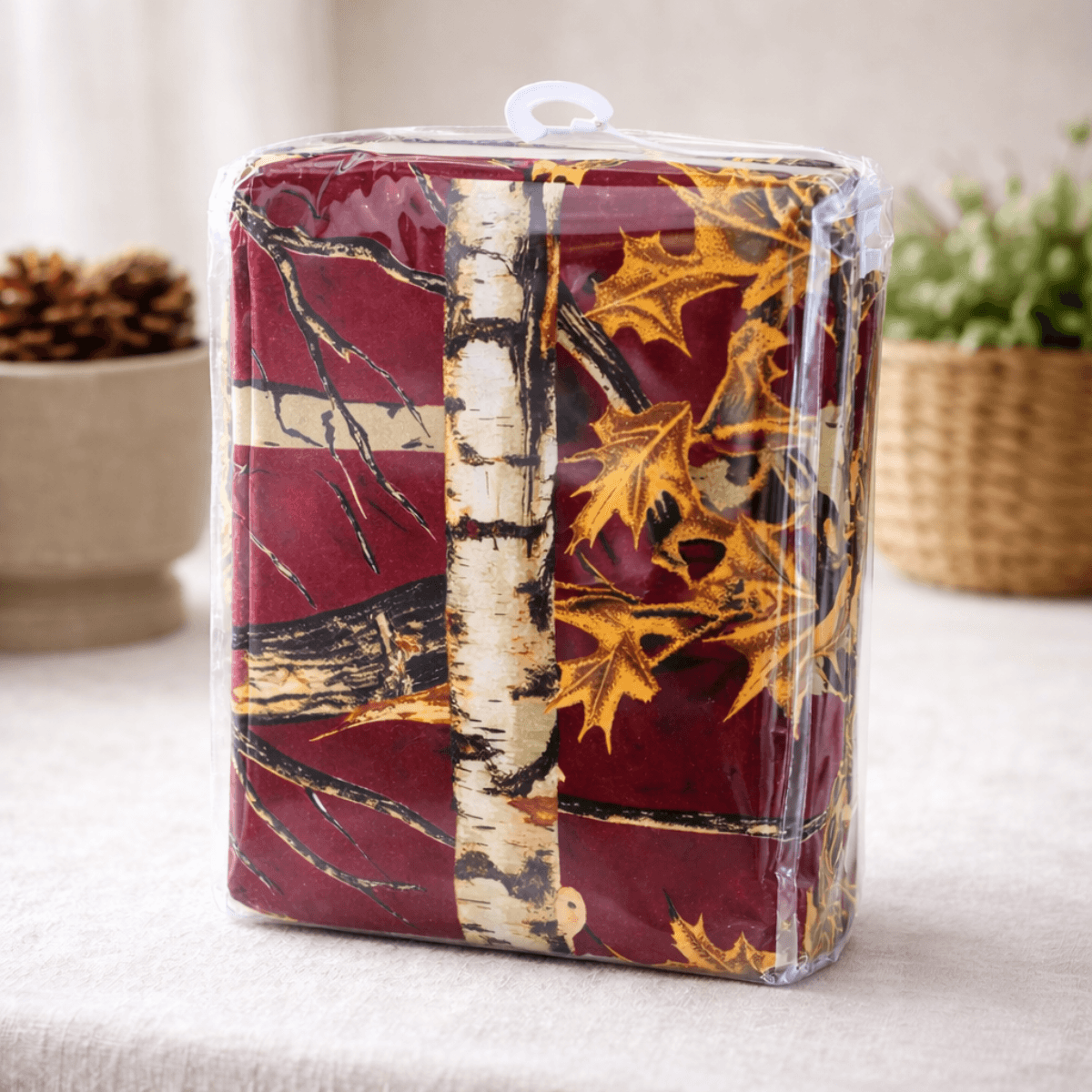 Packaged curtain set with burgundy camouflage themed design featuring leaves and trees on a neutral background.