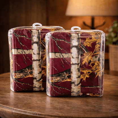 Two packaged curtain sets in a burgundy camouflage pattern on a wooden surface with a blurred background