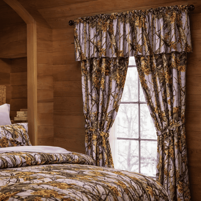 Lavender, camouflage-patterned curtains and bedding in a bedroom with wooden walls.