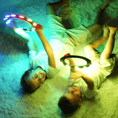 Two children playing with TOSY Flying Rings on a fluffy white carpet