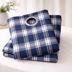 Folded blue and white plaid curtain set with grommet on a light background