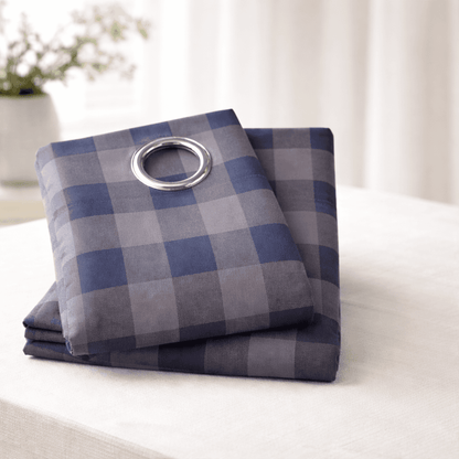 Folded blue and gray checkered curtain set on a white surface