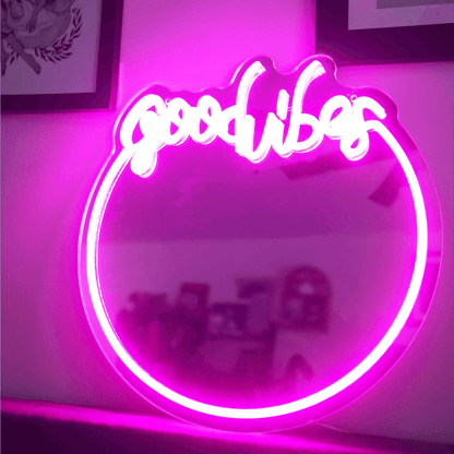Backlit 'Good Vibes' neon sign with mirror frame