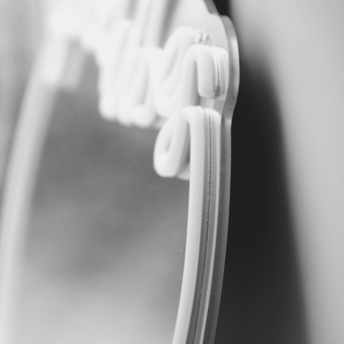 Close-up of white neon 'Good Vibes' sign with mounting clips