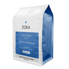 Zoka Tatoosh dark roast coffee bag with blue label, coffee beans, and packaging